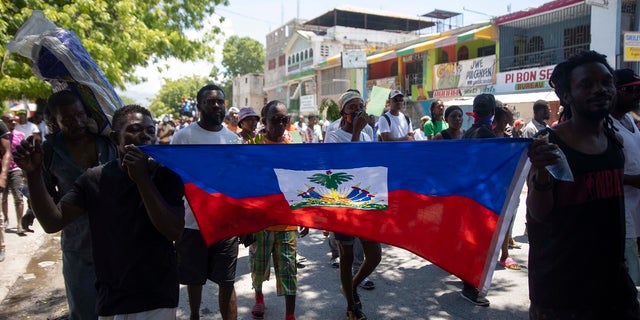 Demonstrators march demanding peace and security in La Plaine neighborhood of Port-au-Prince, Haiti on May 6. The leader of a Haitian gang has been charged in the kidnapping of US missionaries.