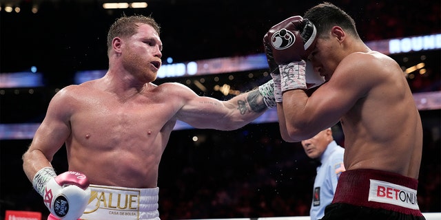 Canelo Alvarez, 左, of Mexico, throws a punch against Dmitry Bivol of Kyrgyzstan during a light heavyweight title fight, 土曜日, 五月 7, 2022, ラスベガスで.