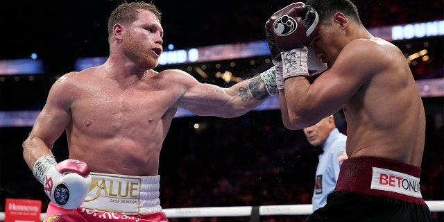 Canelo Alvarez, left, of Mexico, throws a punch against Dmitry Bivol of Kyrgyzstan during a light heavyweight title fight, Saturday, May 7, 2022, in Las Vegas.