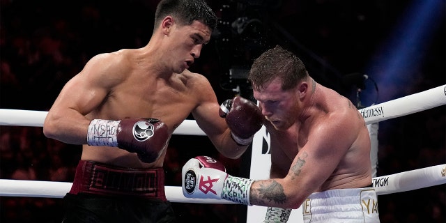 Dmitry Bivol, left, of Kyrgyzstan, throws a punch against Canelo Alvarez of Mexico during a light heavyweight title fight, Saturday, May 7, 2022, in Las Vegas.