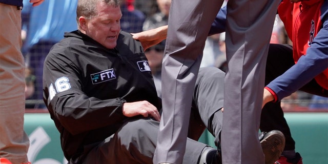 Home plate umpire Ron Kulpa is tended to after being hit with a foul ball during the fourth inning of a game between the Boston Red Sox and the Chicago White Sox at Fenway Park, Sunday, May 8, 2022, in Boston.