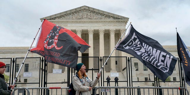 Abortion-rights protesters wave flags during a demonstration outside of the U.S. Supreme Court, Sunday, May 8, 2022, in Washington. A draft opinion suggests the Supreme Court could be poised to overturn the landmark 1973 Roe v. Wade case that legalized abortion nationwide, according to a Politico report released Monday.