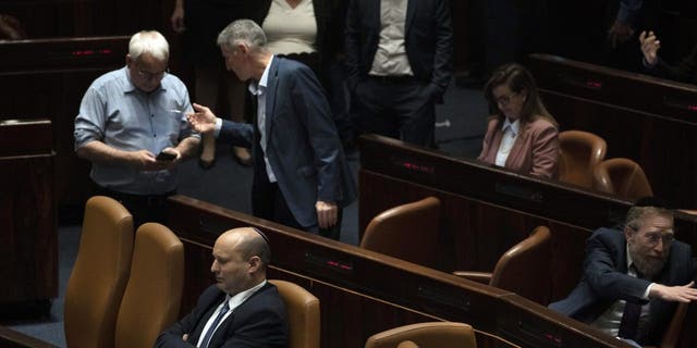Israeli Prime Minister Naftali Bennett, lower left pauses during the opening of the summer session of the Knesset, Israel's parliament, in Jerusalem, Monday, May 9, 2022. 