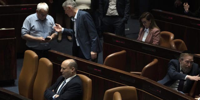 Israeli Prime Minister Naftali Bennett, lower left pauses during the opening of the summer session of the Knesset, Israel's parliament, in Jerusalem, Monday, May 9, 2022.