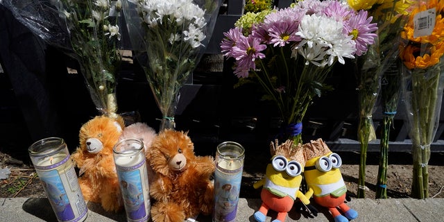 Flowers and teddy bears are left outside a ranch-style house in the West Hills neighborhood of the San Fernando Valley where three children were found dead on Mother's Day. 