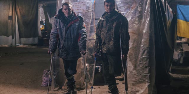 In this photo provided by Azov Special Forces Regiment of the Ukrainian National Guard Press Office, Azov Special Forces Regiment's servicemen, injured during fighting against Russian forces, pose for a photographer inside the Azovstal steel plant in Mariupol, Ukraine, Tuesday, May 10, 2022.