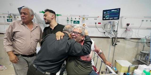 An injured journalist is being hugged by one of the colleagues of killed journalist Shireen Abu Akleh, a journalist for the Al-Jazeera network, in the Hospital West Bank town of Jenin, Wednesday, May 11, 2022. 