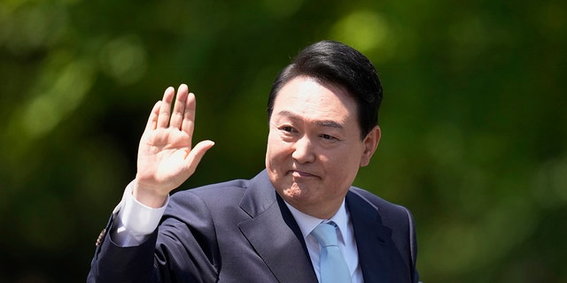 New South Korean President Yoon Seok-yeol waves after his presidential inauguration in front of the National Assembly in Seoul, South Korea, May 10, 2022.
