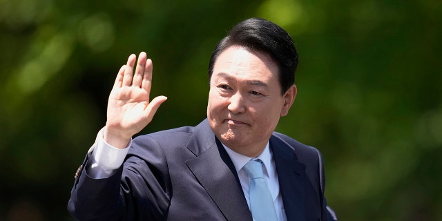 South Korea's new president Yoon Suk-yeol waves after his presidential inauguration in front of the National Assembly in Seoul, South Korea, May 10, 2022.