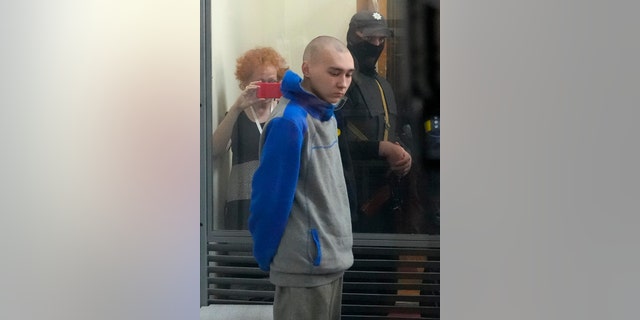Russian army Sergeant Vadim Shishimarin, 21, is seen behind a glass during a court hearing in Kyiv, Ukraine, Friday, May 13, 2022. The trial of a Russian soldier accused of killing a Ukrainian civilian opened Friday, the first war crimes trial since Moscow's invasion of its neighbor. (G3 Box News Photo/Efrem Lukatsky)