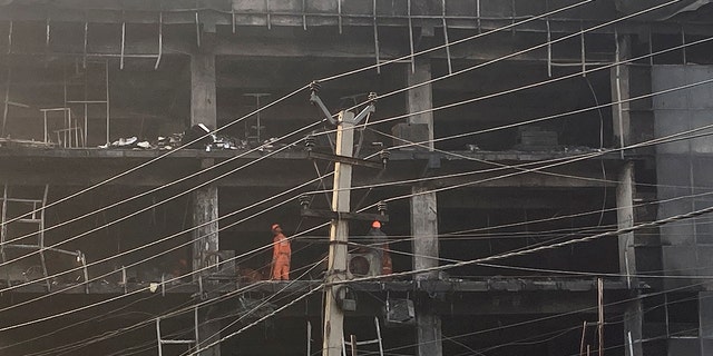 Rescuers work at the site of a fire in New Delhi, India, Saturday, May 14, 2022. A massive fire erupted Friday evening in a four-story commercial building in the Indian capital, killing more than two dozen people and leaving several others injured, the fire control room said. (AP Photo/Shonal Ganguly)