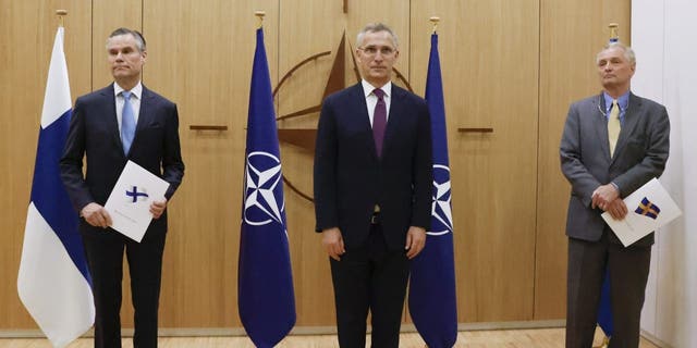 Finland's Ambassador to NATO Klaus Korhonen, left, NATO Secretary-General Jens Stoltenberg and Sweden's Ambassador to NATO Axel Wernhoff attend a ceremony to mark Sweden's and Finland's application for membership in Brussels, Belgium, Wednesday May 18, 2022. 