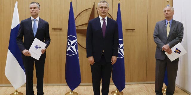 Finland's Ambassador to NATO Klaus Korhonen, left, NATO Secretary-General Jens Stoltenberg and Sweden's Ambassador to NATO Axel Wernhoff attend a ceremony to mark Sweden's and Finland's application for membership in Brussels, Belgium, Wednesday May 18, 2022. 