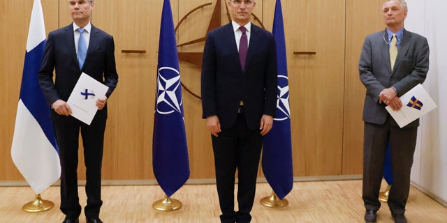 Finland's Ambassador to NATO Klaus Korhonen, left, NATO Secretary-General Jens Stoltenberg and Sweden's Ambassador to NATO Axel Wernhoff attend a ceremony to mark Sweden's and Finland's application for membership in Brussels, Belgium, Wednesday, May 18, 2022.