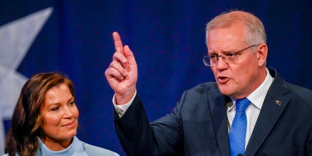 Australian Prime Minister Scott Morrison gestures as his wife Jenny watches as he addresses a Liberal Party function in Sydney, Australia on Saturday 21 May 2022. Morrison admitted defeat and confirmed he would hand over leadership of the Liberal Party later. its the party's defeat against Labor in today's federal elections. 