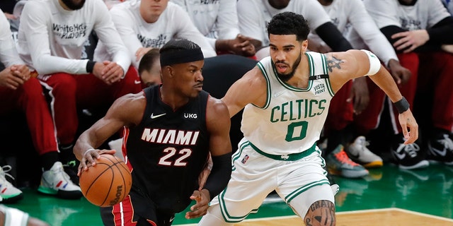 Miami Heat's Jimmy Butler drives against Celtics' Jayson Tatum during the NBA basketball playoffs, May 21, 2022, in Boston.