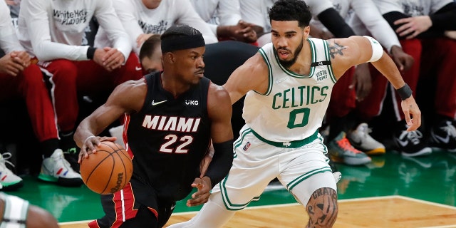 Miami Heat's Jimmy Butler drives against Celtics' Jayson Tatum during the NBA basketball playoffs, May 21, 2022, in Boston.