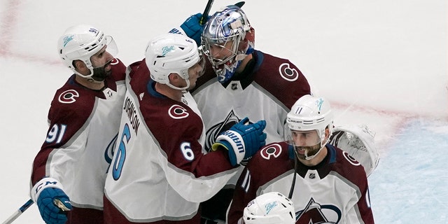 Colorado Avalanche goaltender Darcy Kuemper celebrates with teammates Nazem Kadri (91), Erik Johnson (6) and Andrew Cogliano (11) following a 5-2 victory over the St. Louis Blues in Game 3 of an NHL hockey Stanley Cup second-round playoff series Saturday, Maggio 21, 2022, a St. Louis.