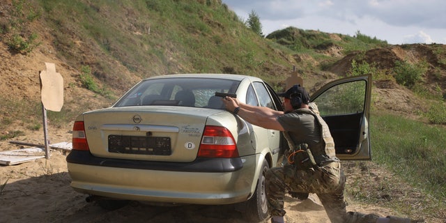 Volunteers from Belarus practice at a shooting range near Warsaw, Poland, Friday, May 20, 2022. The fighters from Belarus are improving their military skills in Poland before deploying to Ukraine, where they plan to join a legion of foreign fighters defending Ukraine against Russian attacks. 