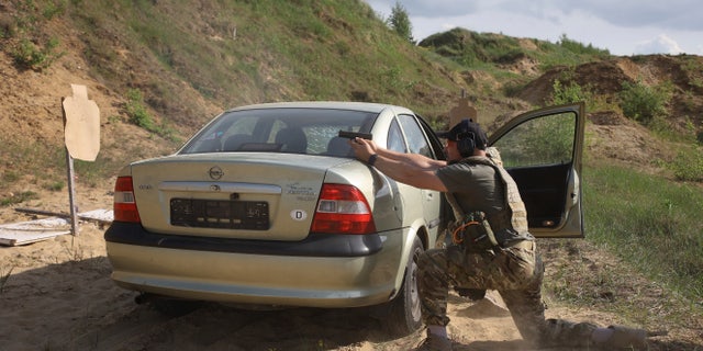 Volunteers from Belarus practice at a shooting range near Warsaw, Poland, Friday, May 20, 2022. The fighters from Belarus are improving their military skills in Poland before deploying to Ukraine, where they plan to join a legion of foreign fighters defending Ukraine against Russian attacks. 