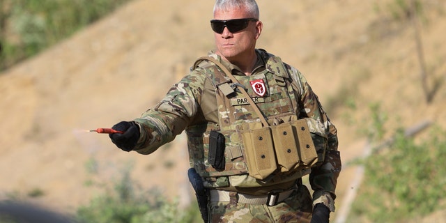 American former army member, Matthew Parker, holds a smoke grenade during a training session for Belarusian volunteers at a shooting range near Warsaw, Poland, on Friday, May 20, 2022. Belarusians are among those who have answered a call by Ukrainian President Volodymyr Zelenskyy for foreign fighters to go to Ukraine and join the International Legion for the Territorial Defense of Ukraine. 