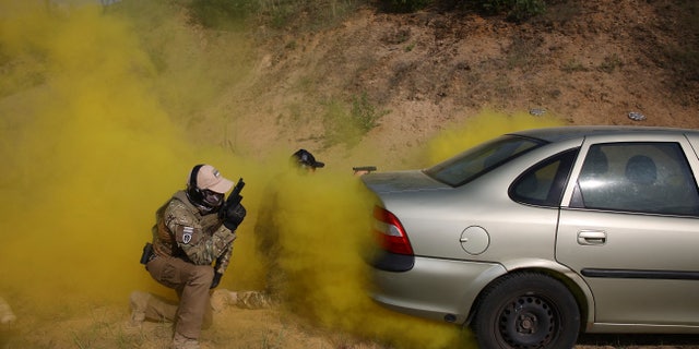 Volunteers from Belarus practice at a shooting range near Warsaw, Poland, on Friday, May 20, 2022. 