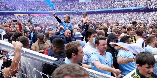 Manchester City fans celebrate after the English Premier League soccer match between Manchester City and Aston Villa at the Etihad Stadium in Manchester, Inghilterra, Domenica, Maggio 22, 2022. Manchester City won the match against Aston Villa and secured the 2022 Premier League title. 