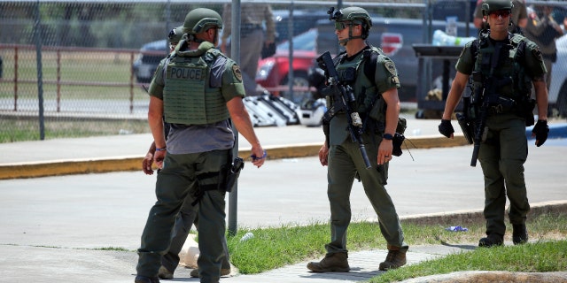 Law enforcement personnel stand outside Robb Elementary School following a shooting, Tuesday, May 24, 2022, in Uvalde, Texas.