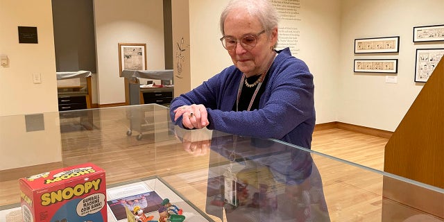 Lucy Shelton Caswell, founding curator of the Billy Ireland Cartoon Library Museum, examines memorabilia tied to the comic strip "Peanuts" on Friday, May 20, 2022, in Columbus, Ohio.