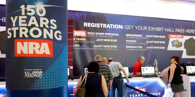 Convention attendees line up at the registration booth during the NRA Annual Meeting held at the George R. Brown Convention Center Thursday, May 26, 2022 in Houston. (AP Photo/Michael Wyke)