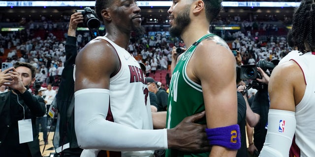 Le centre de Miami Heat Bam Adebayo (13) félicite l'attaquant des Boston Celtics Jayson Tatum (0) après que les Celtics ont remporté le match 7 de la série éliminatoire de la finale de la NBA Basketball Eastern Conference, dimanche 29 mai 2022, à Miami.