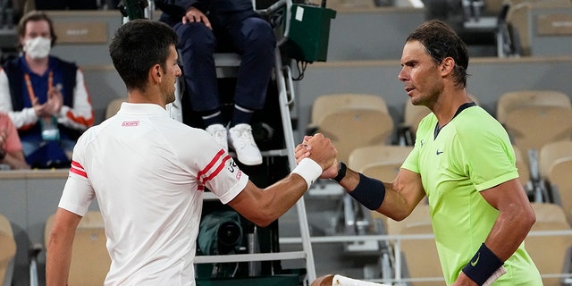 Serbia's Novak Djokovic, left, shakes hands with Spain's Rafael Nadal after their semifinal match of the French Open tennis tournament at the Roland Garros stadium in Paris on June 11, 2021.