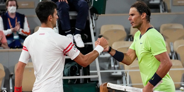 Serbia's Novak Djokovic, left, shakes hands with Spain's Rafael Nadal after their semifinal match of the French Open tennis tournament at the Roland Garros stadium in Paris on June 11, 2021.