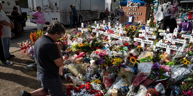 Salvatore Di Grazia, a visiting teacher from the Rio Grande Valley, Texas, prays before a memorial at Robb Elementary School in Uvalde, Texas, Monday, May 30, 2022, for the victims killed in the shooting in a school last week.