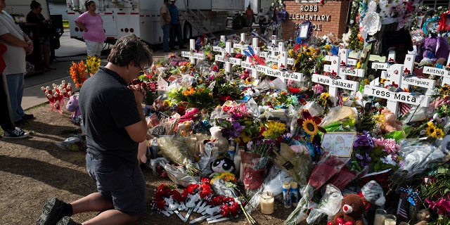 Salvatore Di Grazia, a teacher visiting from Rio Grande Valley, Texas, prays at a memorial at Robb Elementary School in Uvalde, Texas Monday, May 30, 2022, for the victims killed in last week's school shooting.