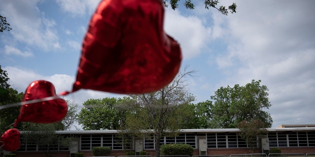 A heart-shaped balloon flies decorating a memorial site outside Robb Elementary School in Uvalde, Texas, Monday, May 30, 2022.