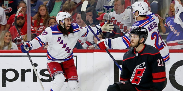 New York Rangers' Mika Zibanejad, left, congratulates Chris Kreider (20) on his goal behind Carolina Hurricanes' Brett Pesce (22) during the first period of Game 7 of an NHL hockey Stanley Cup second-round playoff series in Raleigh, N.C., Monday, May 30, 2022.
