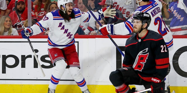 New York Rangers' Mika Zibanejad, left, congratulates Chris Kreider (20) on his goal behind Carolina Hurricanes' Brett Pesce (22) during the first period of Game 7 of an NHL hockey Stanley Cup second-round playoff series in Raleigh, N.C., Monday, May 30, 2022.
