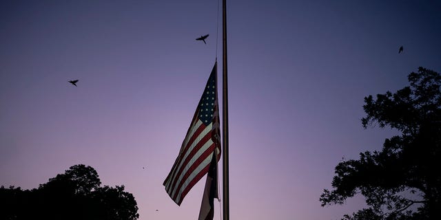 The American and Texas flags are flown at half-staff at dusk on Thursday, May 26, 2022, days after a deadly school shooting, in Uvalde, Texas.