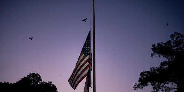 The American and Texas flags are flown at half-staff at dusk on Thursday, May 26, 2022, days after a deadly school shooting, in Uvalde, Texas.