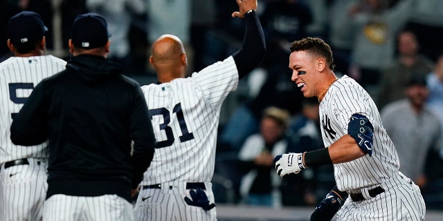 Yankees' Aaron Judge celebrates with teammates at home plate after hitting a walk-off three-run home run against the Toronto Blue Jays Tuesday, May 10, 2022, in New York.