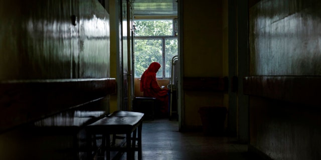 An Afghan mother sits by her child's bed at the malnutrition ward of the Indira Gandhi hospital in Kabul, Afghanistan, Sunday, May 22, 2022.