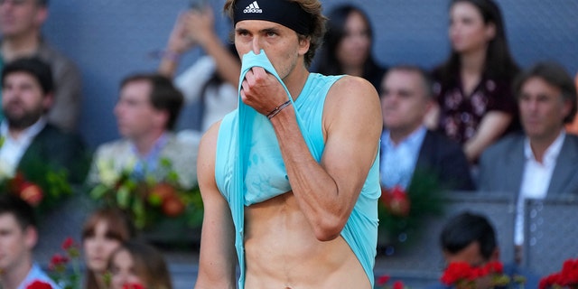 Alexander Zverev pulls off his jersey during the final match with Carlos Alcaraz at the Spanish Madrid Open on Sunday, May 8, 2022.