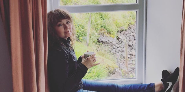 Ohio writer and teacher Amanda Page poses with a cup of tea on a windowsill in Scotland during a vacation. (Amanda Page)