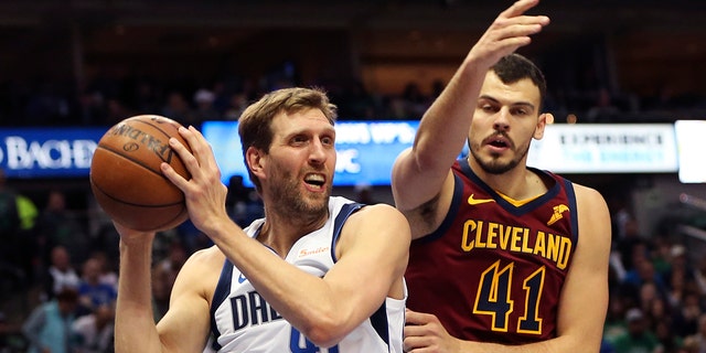 Mavericks forward Dirk Nowitzki looks to pass as Cleveland Cavaliers center Ante Zizic defends at American Airlines Center on March 16, 2019, in Dallas.