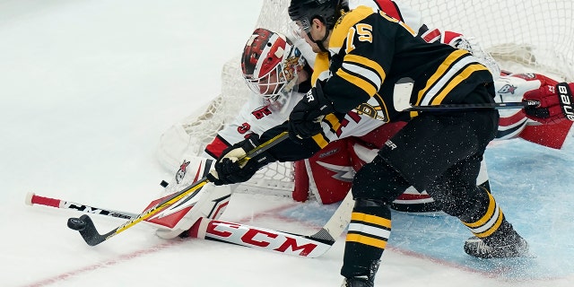 Carolina Hurricanes 'Antti Raanta and Bruins' Connor Clifton vie for control of the puck in the first-round playoff series on Sunday 8 May 2022 in Boston.