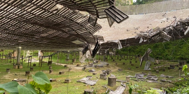 This photo provided by the Arecibo Observatory, shows the damage done by a broken cable that supported a metal platform, creating a 100-foot (30-meter) gash to the radio telescope's reflector dish in Arecibo, Puerto Rico, Tuesday, Aug. 11, 2020. 