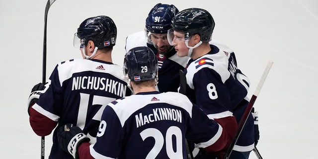 Colorado Avalanche defenseman Cale Makar, 正しい, is congratulated by right wing Valeri Nichushkin, 左, center Nathan MacKinnon, front center, and center Nazem Kadri for Makar's goal during the first period of an NHL hockey game against the Nashville Predators on Thursday, 4月 28, 2022, デンバーで.