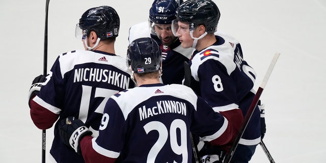 Colorado Avalanche defenseman Cale Makar, 正しい, is congratulated by right wing Valeri Nichushkin, 左, center Nathan MacKinnon, front center, and center Nazem Kadri for Makar's goal during the first period of an NHL hockey game against the Nashville Predators on Thursday, 4月 28, 2022, デンバーで.