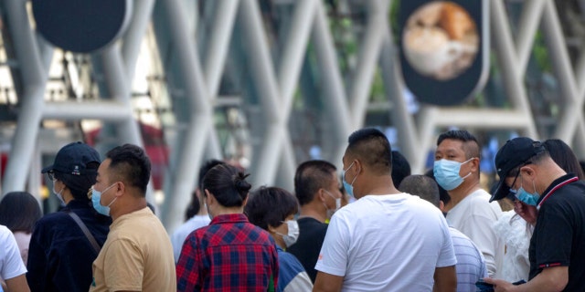 People wearing face masks stand in line for COVID-19 tests at a testing site during the second consecutive day of mass testing in Beijing, Wednesday, May 4, 2022. Beijing on Wednesday closed around 10% of the stations in its vast subway system as an additional measure against the spread of coronavirus. 